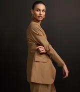 Blazer color camel de poliéster y viscosa, corte sastre comfort, con solapa en el cuello, abotonado delantero, solapas delanteras que simulan bolsillos y puntadas de costuras discretas coloridas.