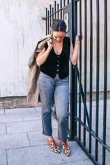 Zapatos tipo blucher de pelo de pony con estampado animal print. Presentan cierre de cordones rojos, ribetes de ante a contraste y una silueta geométrica con aberturas laterales. Cuentan con tacón forrado de 2 cm en forma de lágrima y suela de cuero.