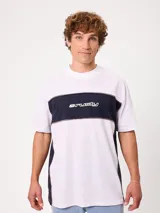 Remera holgada Rusty de diseño combinado en blanco y azul marino, con cuello redondo ancho, mangas cortas y detalle de ribetes oscuros a contratono. Cuenta con el logotipo de la marca estampado en el pecho.