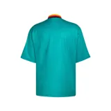 Camiseta de fútbol Adidas retro de la selección de Alemania, diseño alternativo de 1994. Color principal verde turquesa con cuello en V amarillo, rojo y negro, y un llamativo estampado geométrico en el pecho y las mangas en tonos negro, rojo y amarillo.