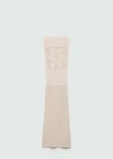Vestido largo de tejido de punto calado en color crudo, con tirantes finos y escote cuadrado. Presenta un diseño recto y ajustado al cuerpo.