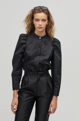 Camisa negra de popelina de algodón con cuello mao, mangas largas abullonadas y botones de nácar. Presenta corazones bordados y aplicados en el frente.