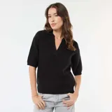 Sweater de punto en color negro, con cuello en pico y mangas cortas. Presenta un diseño de tejido acanalado y corte recto.