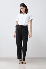 Pantalón de vestir color beige, de corte recto, con pinzas, bolsillos laterales y cinturón con hebilla forrada.