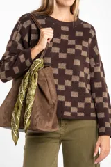 Sweater de punto con diseño de cuadros en tonos marrón y beige, de corte recto, cuello redondo y manga larga.