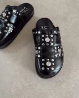 Zuecos negros con apliques de tachas plateadas y strass.