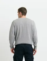 Sweater de punto color ladrillo con cuello en V y mangas largas.