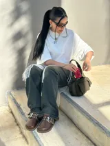 Zueco marrón de cuero con hebilla metálica ajustable, plantilla de cuero y suela de goma.