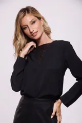 Blusa negra de mangas largas con detalle de encaje en el escote.