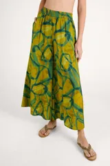 Pantalón de corte fluido color mostaza, con estampado geométrico abstracto en tonos verdes, cintura elástica y diseño amplio.