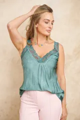 Musculosa de seda color verde con escote en V y detalles de encaje floral en el escote y los tirantes.