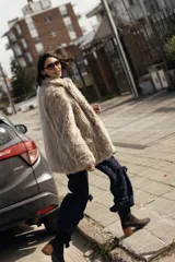 Campera oversize de largo medio en piel sintética, de diseño relajado con bolsillos funcionales y detalles bordados en la espalda.