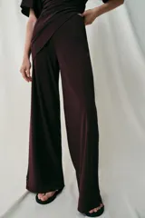 Pantalón largo color bordó, confeccionado en crepe fluido, con tiro alto, cintura elástica y diseño de pierna ancha.