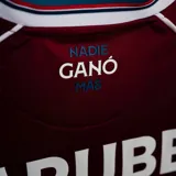 Camiseta de arquero Umbro del Club Nacional de Football, color bordó con detalles en blanco y azul. Presenta cuello en V, sponsors estampados y escudo del club en el pecho.