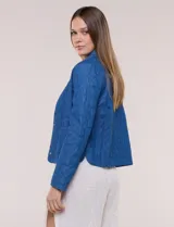 Chaqueta azul de algodón con diseño acolchado y bordado de flores, cuello redondo y cierre frontal con botones a presión metálicos. Incluye bolsillos delanteros y forro interno a tono.