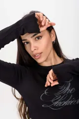 Remera de manga larga gris de corte ajustado, con cuello redondo y estampado frontal con la frase "The Luckiest".