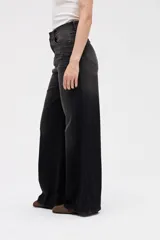 Jean de tiro alto y corte wide leg, con diseño de paneles laterales en tono más oscuro que el centro. Presenta cierre frontal con botón y bolsillos clásicos.