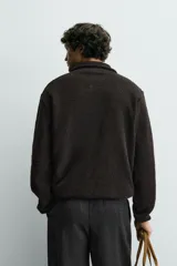 Sudadera de corte regular confeccionada en tejido de borreguillo con textura, cuello subido con cierre frontal de cremallera y manga larga con acabados en cinta.