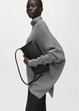 Jersey gris de punto con cuello vuelto, diseño oversize de manga larga y silueta asimétrica.