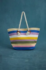 Bolso tipo tote rayado horizontalmente en colores azul, rosa, verde, amarillo, blanco y beige. Tiene asas de soga gruesa y apliques de cuero sintético marrón.