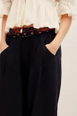 Pantalón babucha negro de lino, de corte holgado estilo barrel con pinzas en la cintura y bolsillos laterales.