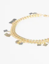 Tobillera plateada de doble cadena con dijes colgantes en forma de rombo.