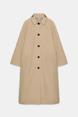 Trench reversible de Zara Woman Collection con diseño de cuadros en tonos beige, negro y tostado. Cuenta con cuello de solapa, cierre frontal con botones oscuros y bolsillos delanteros diagonales.