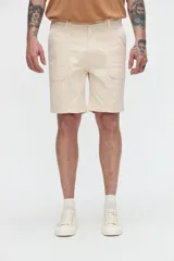 Bermuda cargo de gabardina en color beige, con bolsillos laterales y bolsillos cargo con solapa y velcro.