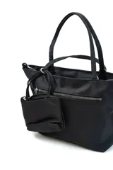 Cartera tipo shopper color negro con doble asa de mano, cierre superior y un pequeño monedero o neceser desmontable con cierre colgando del lateral.