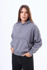 Buzo tipo canguro de felpa con efecto lavado, color violeta, con capucha, bolsillo frontal tipo canguro y mangas largas con puños ajustados.