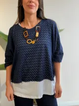 Buzo azul marino con diseño calado de manga corta y corte oversize, acompañado por una musculosa blanca básica interior.