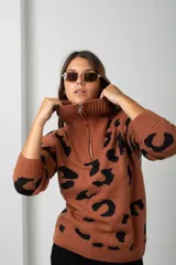 Buzo de tejido de punto con estampado animal print, cuello alto con cierre frontal y mangas largas.