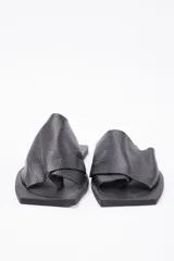 Sandalia tipo chata de cuero vacuno marrón, con diseño de tiras cruzadas y suela plana.