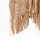 Ruana dorada de tejido calado con flecos.