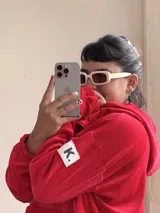 Buzo rojo de plush con capucha, bolsillo, cuello con cierre y elástico ajustable en el ruedo.