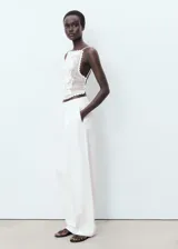 Top halter blanco de crochet con diseño entallado, espalda abierta con tirantes finos cruzados y detalles de ondas en los bordes.