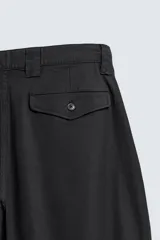 Pantalón de corte relaxed fit confeccionado en mezcla de algodón y modal. Presenta cintura con pliegues frontales, bolsillos laterales y bolsillos traseros con solapa. Cierre frontal con cremallera y botón.