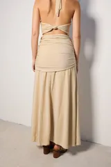 Falda larga de tejido brillante color azul con detalle de nudo en la cintura.