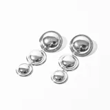 Aros colgantes plateados con tres dijes circulares de diferentes tamaños.