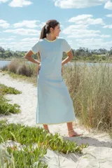 Vestido largo celeste con cuello redondo y mangas cortas con ribete amarillo.