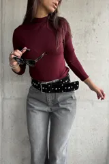 Polera de cuello alto y manga larga, confeccionada en tejido de punto acanalado de color bordó.