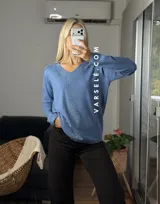 Sweater de punto color bordó con escote en V y detalle de strass aplicado en la parte frontal. Presenta mangas largas y corte holgado.