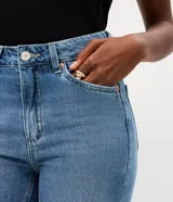 Pantalón de jean corte recto cropped con cintura alta, cierre frontal con cremallera y botón, y bolsillos funcionales. Confeccionado en algodón certificado.
