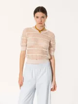 Top de tejido crochet color beige, con cuello redondo y mangas cortas con terminación ondulada.