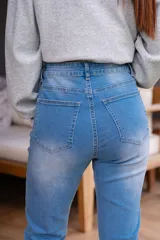 Jean celeste de tiro alto con cinco bolsillos, cierre frontal con cremallera y botón.