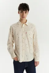 Camisa de manga larga color crema con estampado de montañas en marrón. Tiene un bolsillo en el pecho con el logo de la marca.
