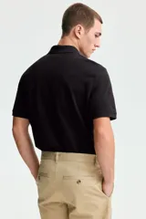 Remera polo de manga corta en piqué de algodón con cuello y tapeta de botones. Corte estándar para una silueta clásica y cómoda.