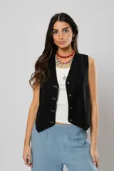 Chaleco negro con escote en V, sin mangas y cierre frontal con botones. Presenta pespuntes en color crudo en la parte delantera y logo bordado en la espalda.