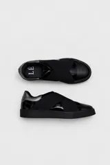 Zapatillas de diseño slip-on combinadas en tonos marrón, negro y blanco, con bandas elásticas cruzadas en el empeine, puntera blanca y suela de goma.