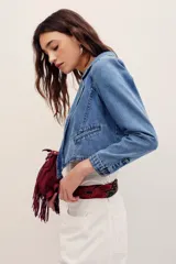 Saco corto de denim azul con solapas y bolsillos ribeteados, confeccionado en mezcla de algodón y poliéster.